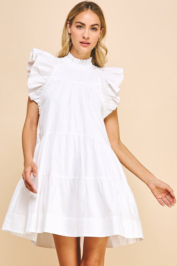 Woman wearing white tiered dress with ruffle sleeves