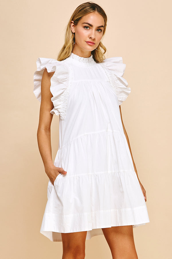 Woman wearing white tiered dress with ruffle sleeves