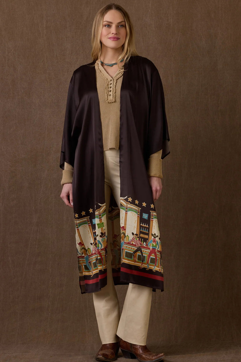 Woman wearing a long, dark brown coat with colorful patterns on a brown background