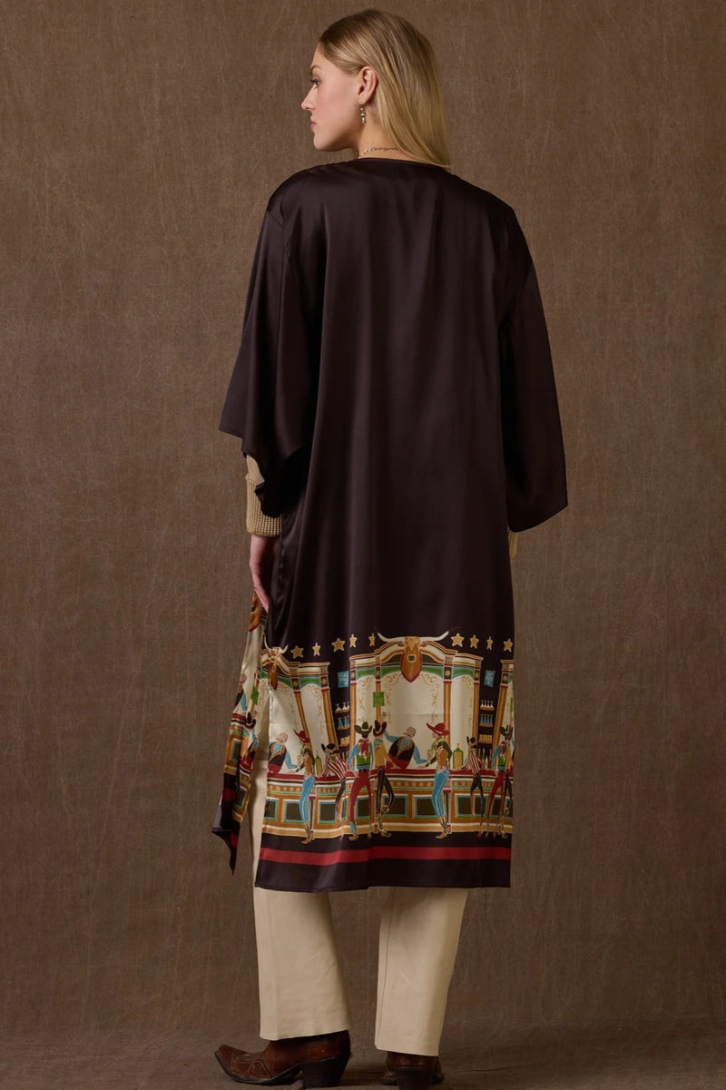Woman wearing a dark brown coat over a patterned dress with a plain background