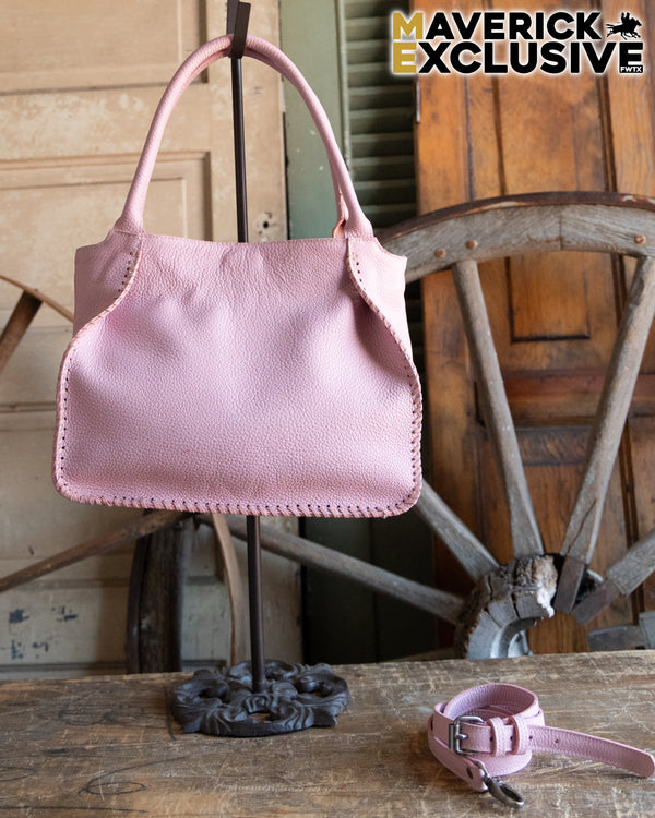 Pink handbag and matching dog collar on a wooden surface with rustic background