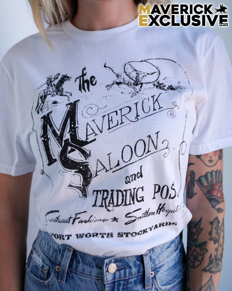 Person wearing a white t-shirt with 'Maverick Saloon' design and tattoos visible.