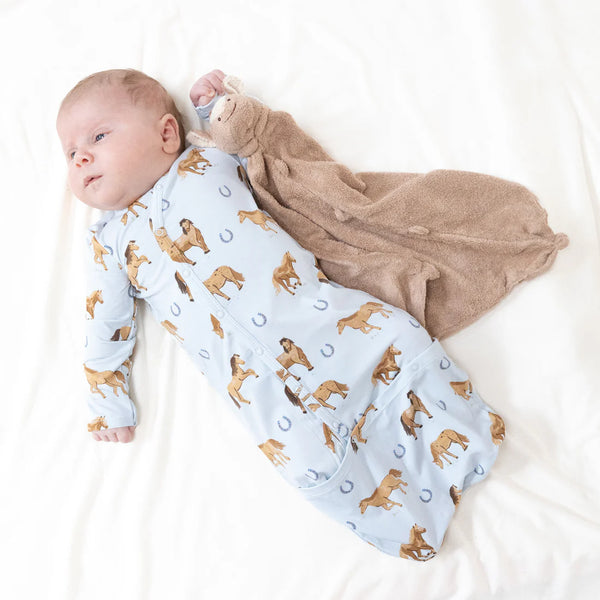 Baby wrapped in a blanket with animal patterns on a white background