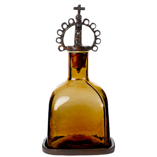 Mouth blown decanter, the color of toasted tobacco, resting in a wax cast tray, topped with a jubilant