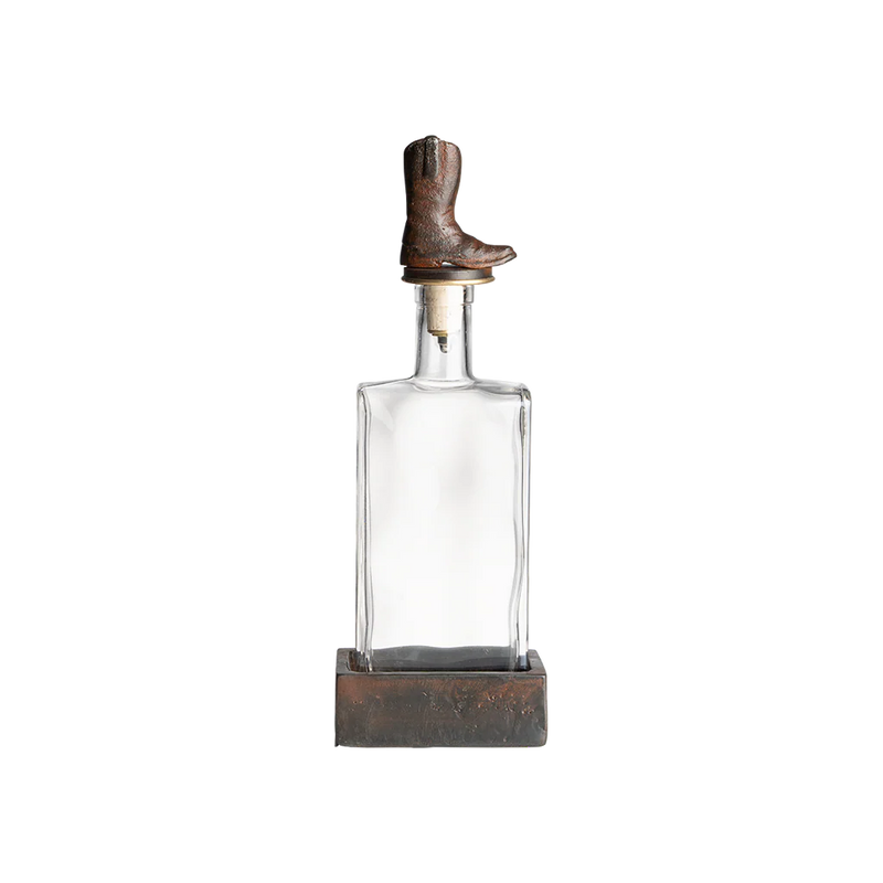 Clear glass decanter with a boot-shaped stopper on a white background