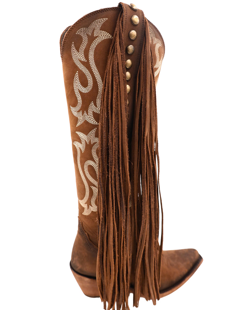 Tall brown boot with white western embroidery with long fringe on the outsides on the boot with brass studs going down the boot. The inside of the boot has a zipper