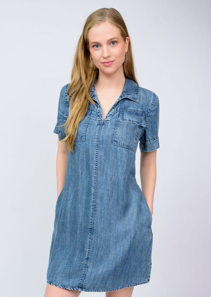 Woman wearing a denim dress against a plain background