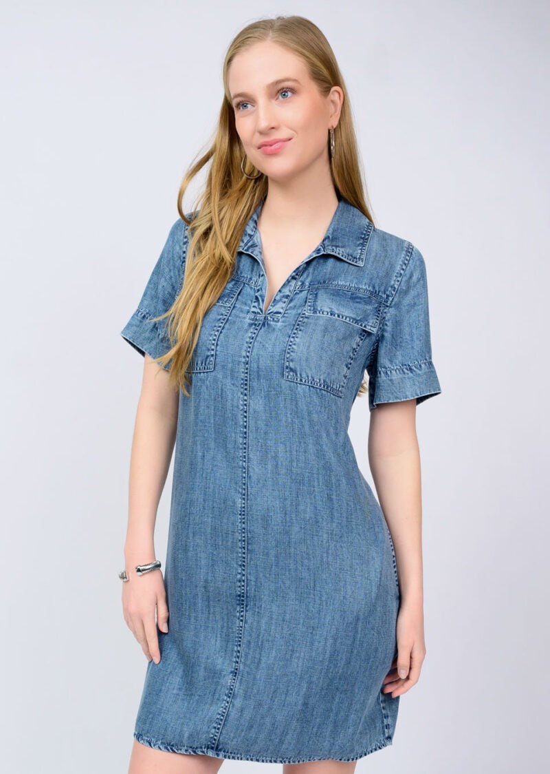 Woman wearing a denim dress against a plain background