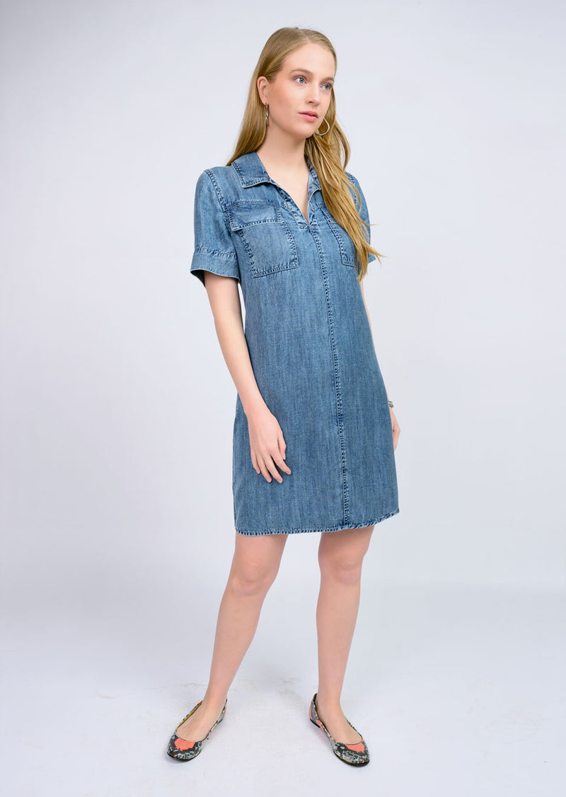 Woman wearing a denim dress against a white background