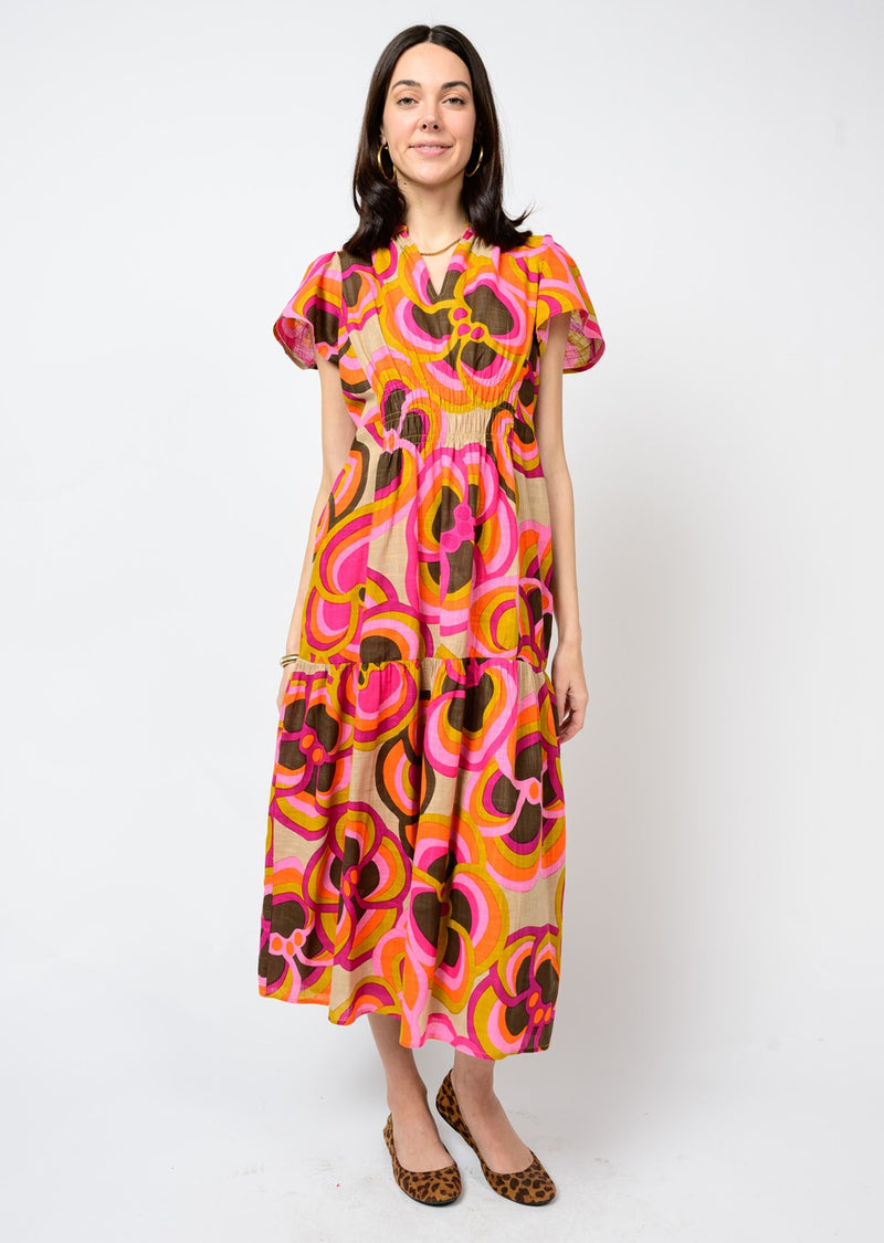 Woman wearing a colorful patterned dress against a white background