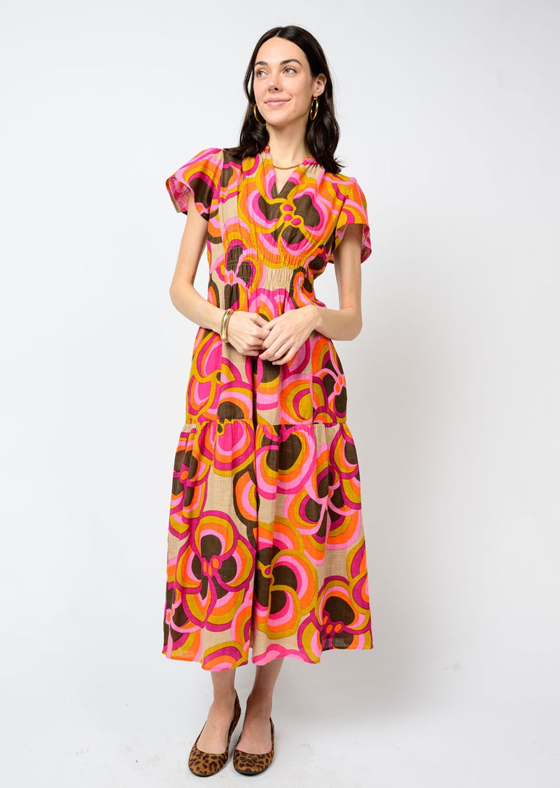 Woman wearing a colorful floral dress against a white background
