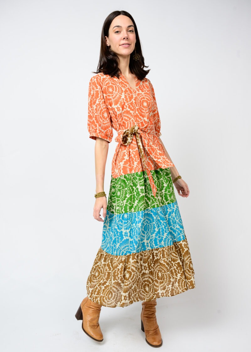 Woman wearing a colorful patterned dress with a white background