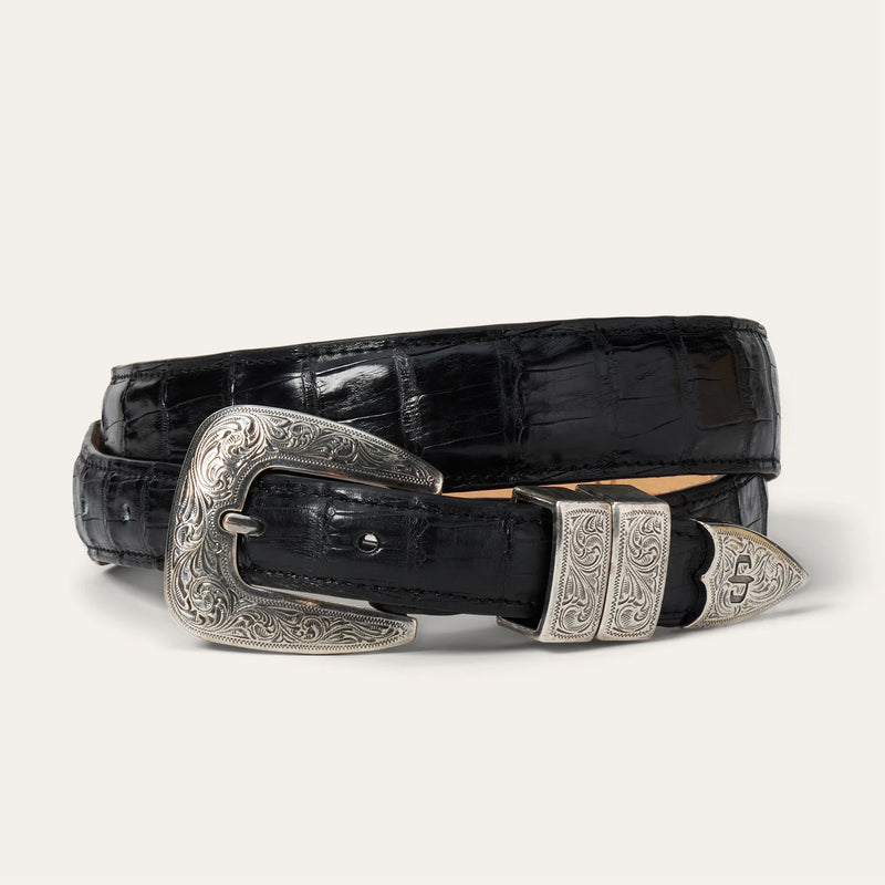 Black crocodile skin belt with silver buckle on a white background