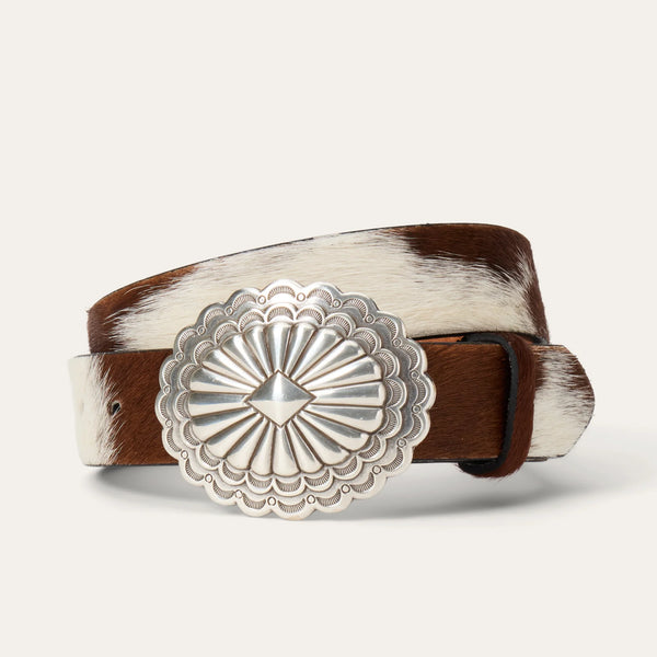 Belt with a brown and white pattern and a silver concho buckle on a light gray background