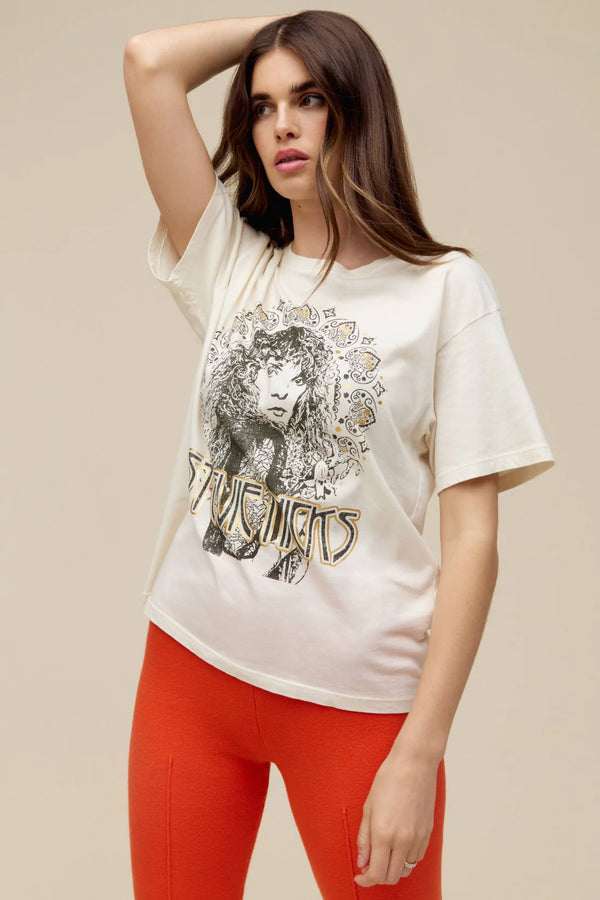 Woman wearing a portrait fit to represent the icon’s free-spirited energy and 70s bohemian style lands center accented in metallic ink t shirt