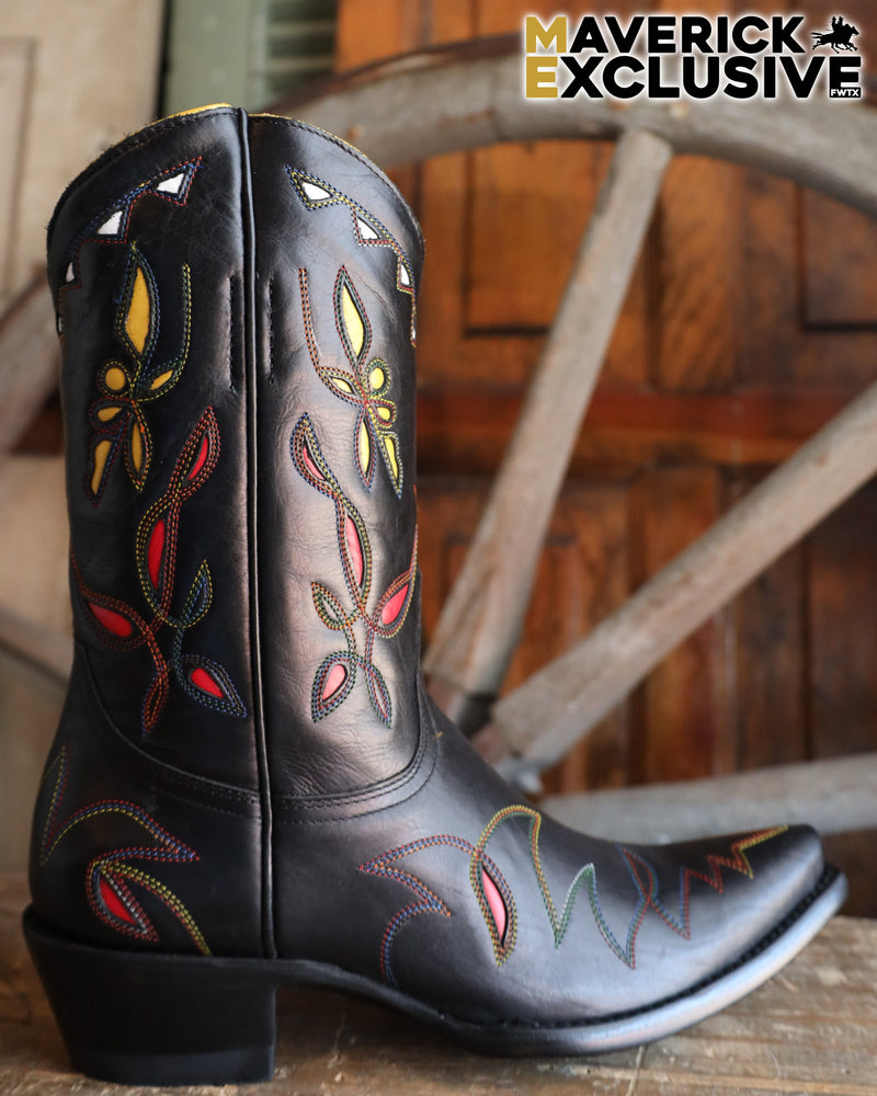 Black cowboy boot with colorful embroidery on a wooden surface, with 'Maverick Exclusive' branding.