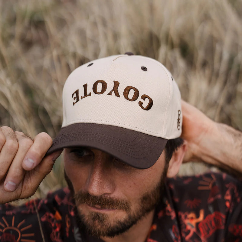 Man wearing a cap with 'GOYOTE' branding in a natural setting