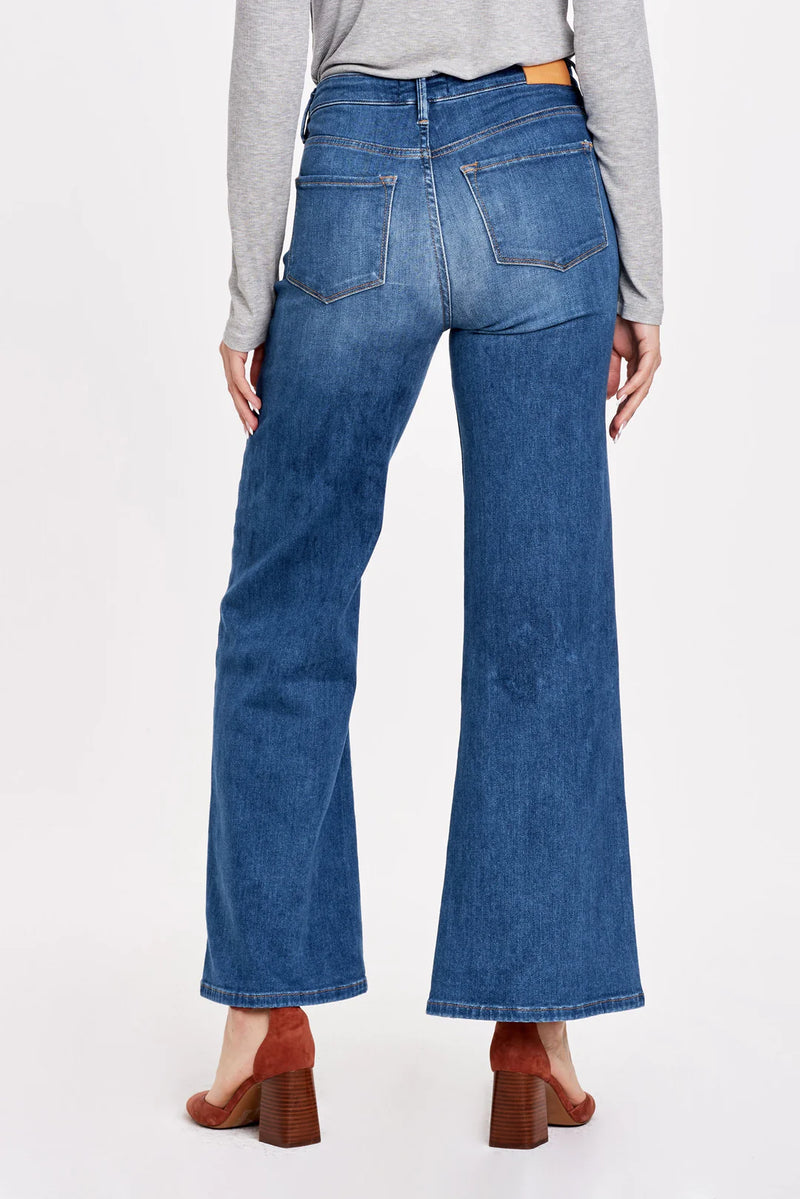 Woman wearing super high rise wide leg jeans with button up front 