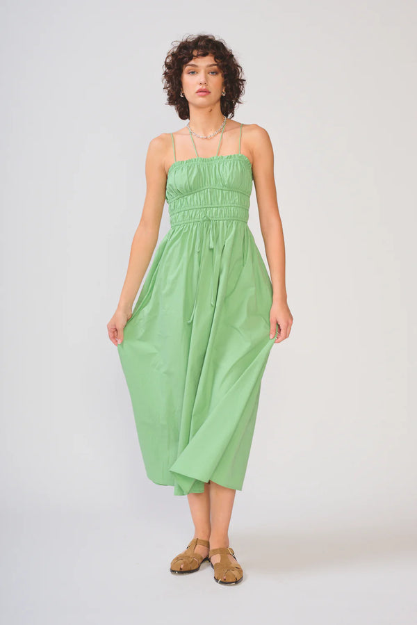 Woman wearing a green strapless dress on a white background