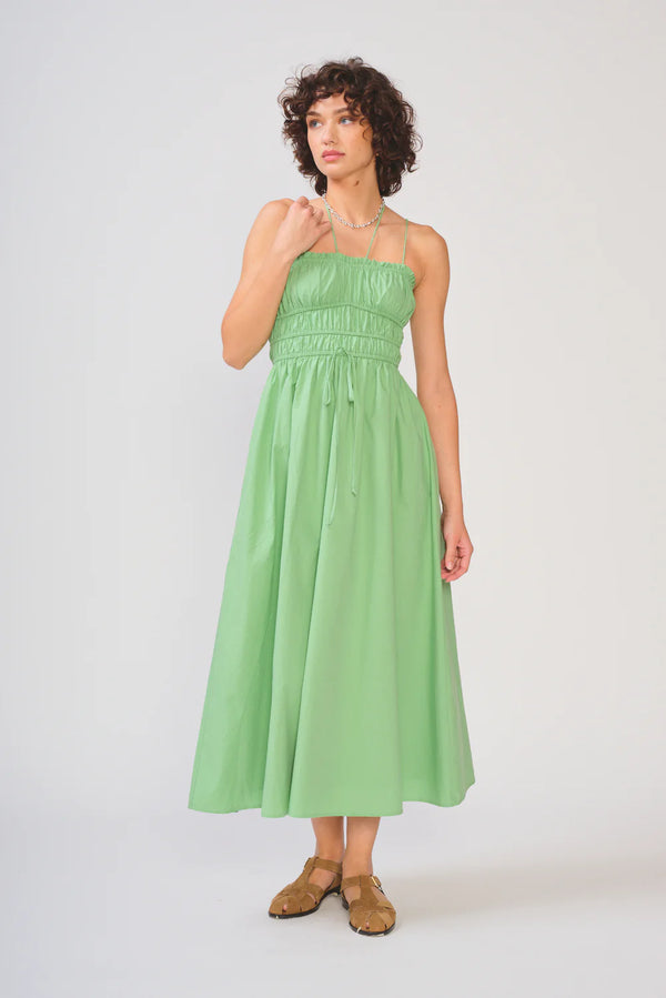 Woman wearing a green strapless dress on a white background
