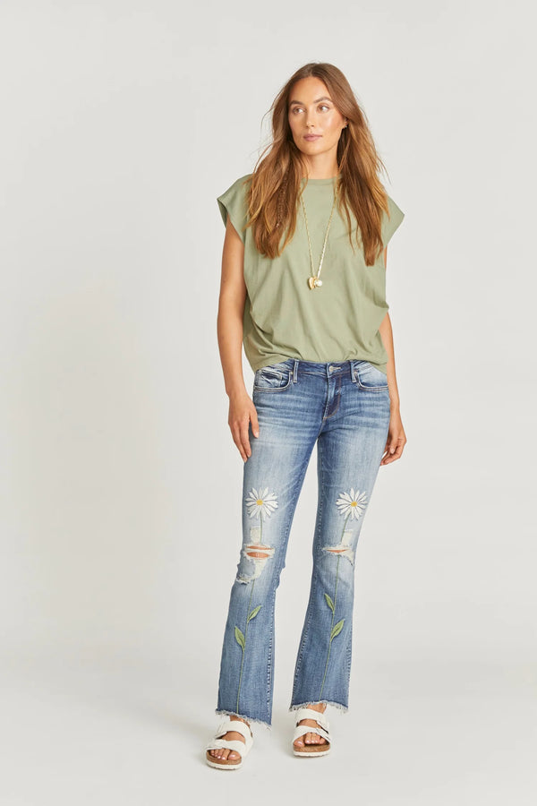 Medium wash Eva boot cut jean featuring rips on the knees, a high low frayed hem and two daisy flowers, one embroidered on each front leg.