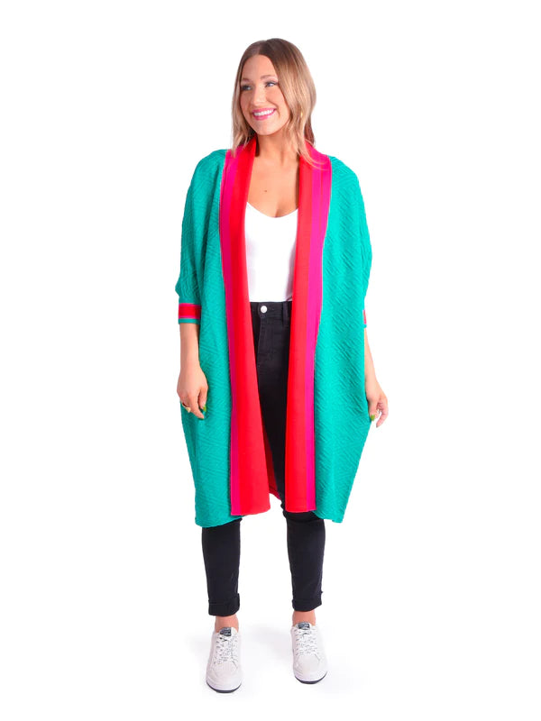 Long green cardigan with quarter sleeves and pink and red accent striped on cuff, collar and down the center of the back