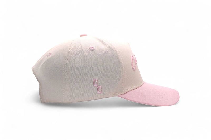 Two-tone beige and pink cap on a white background