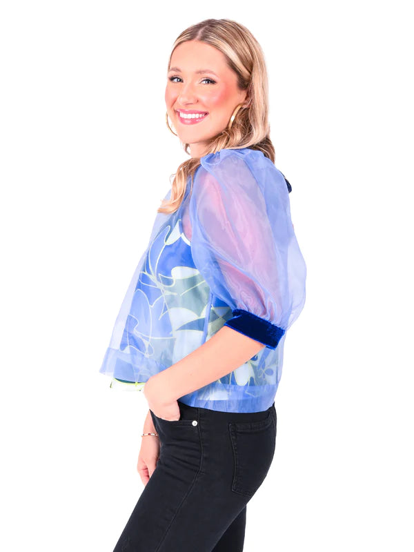 Woman wearing dainty organza along with puff sleeves and velvet trim top