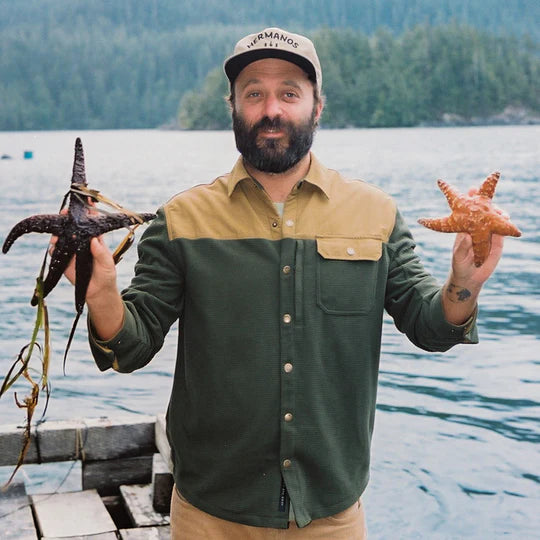 MAN HOLDING STARFISH ON BOAT DOCK WEARING OLIVE AND MUSTARD LONG SLEEVE FLEECE OVERSHIRT WEITH FRONT BREAST POCKET