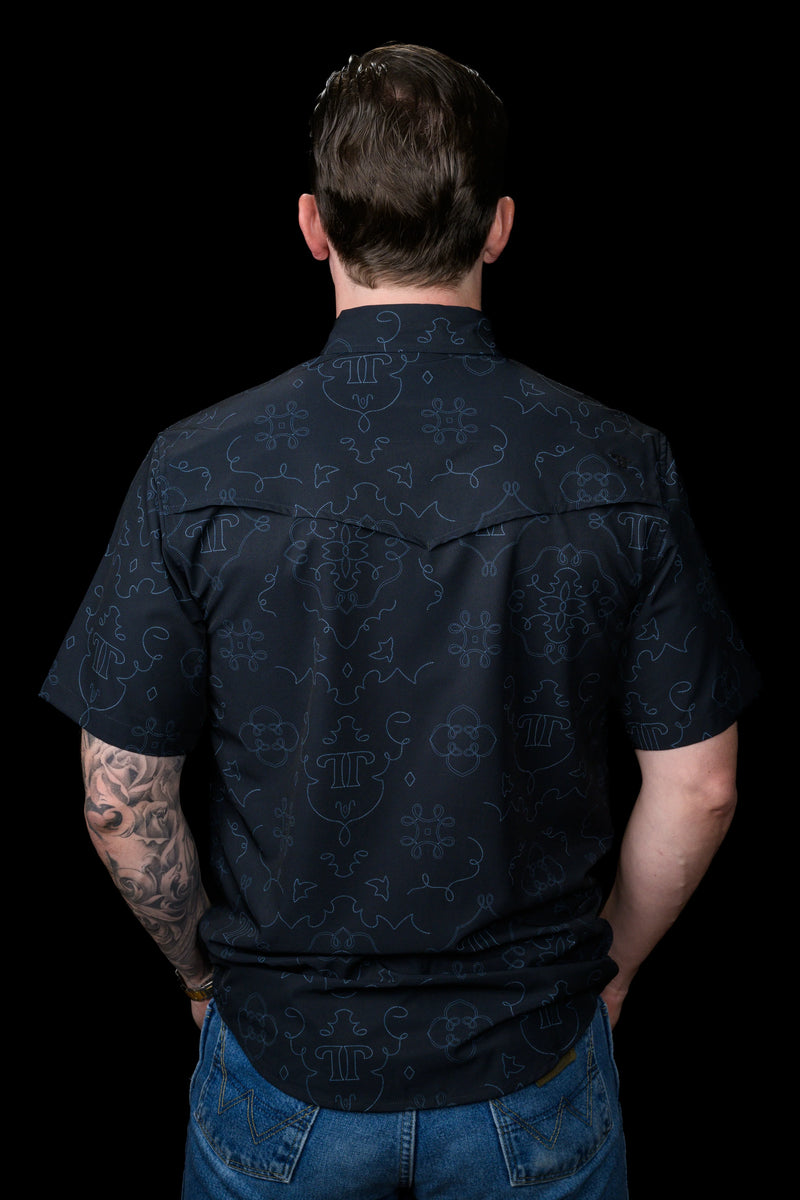 Man wearing a dark blue patterned shirt with a black background