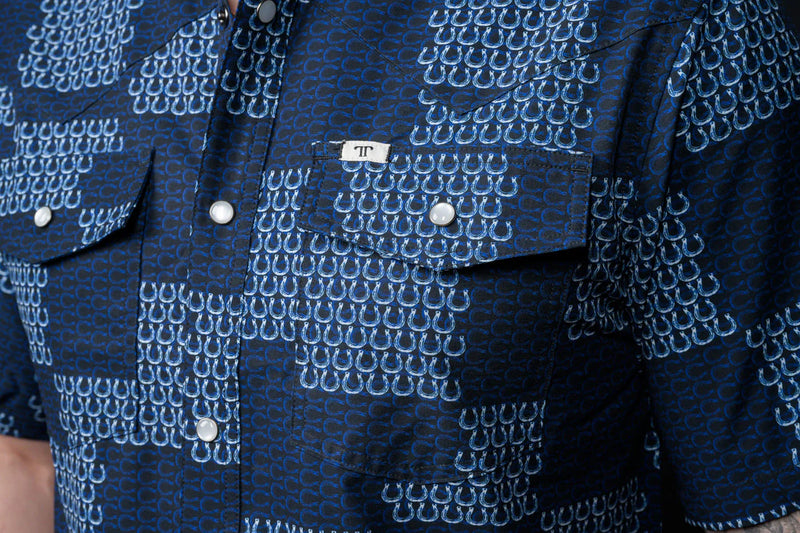 Close-up of a blue patterned shirt with a brand label.
