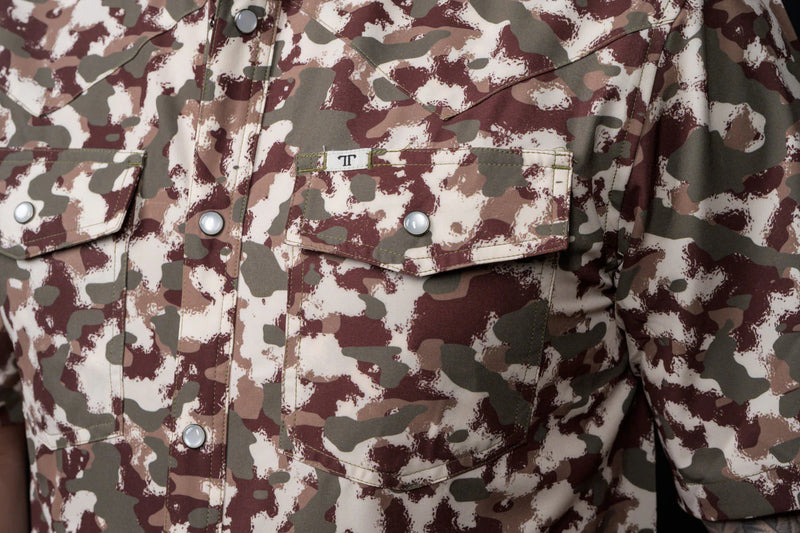 Close-up of a camouflage-patterned shirt with buttons and a pocket.