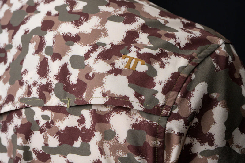 Camouflage-patterned fabric with a logo on a dark background