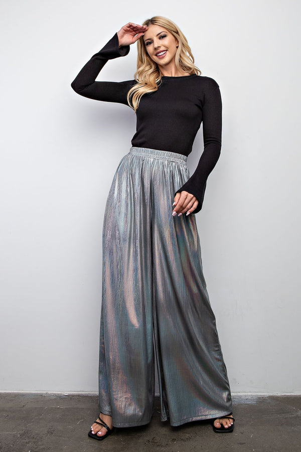 Woman wearing holographic flowy pants with elastic waistband 