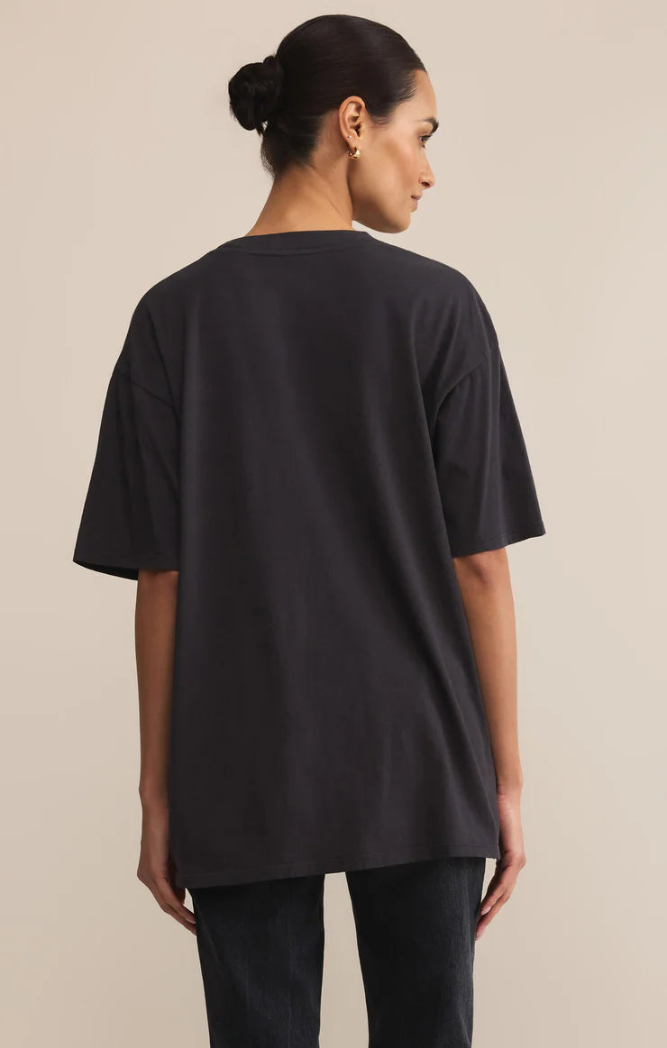 Woman wearing a black oversized t-shirt against a beige background
