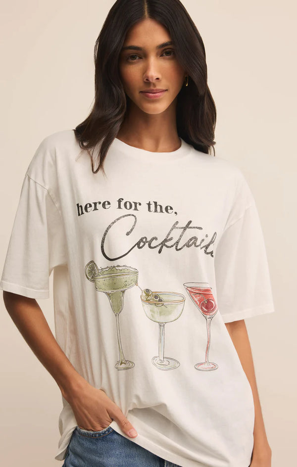 Woman wearing a white t-shirt with cocktail graphics and text.