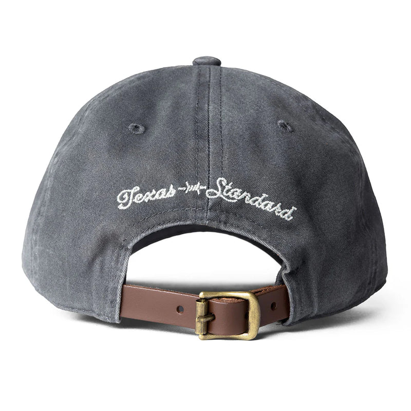 Gray cap with 'Texas Standard' logo and brown leather strap on a white background