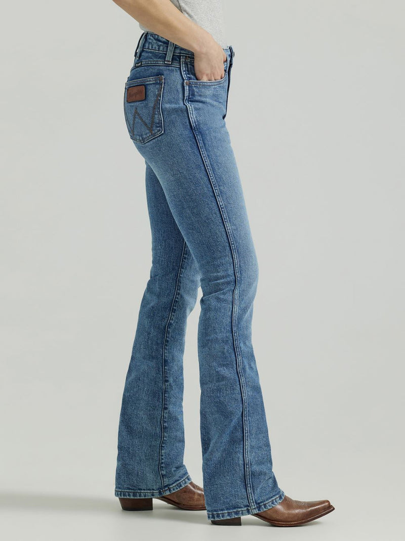 Woman wearing medium wash boot cut jeans with low ride waste