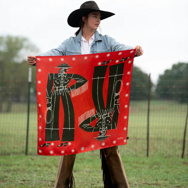 Woman holding red scarf with two abstract cowgirls on front and star burst boarder