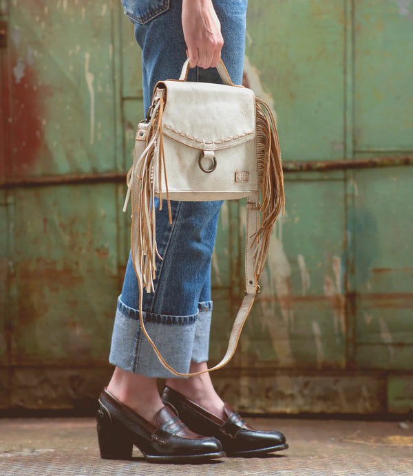 Distress white leather envelope bag with fringe on the sides and handle and detachable crossbody strap