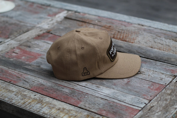 Brown cap with a patch on a rustic wooden surface