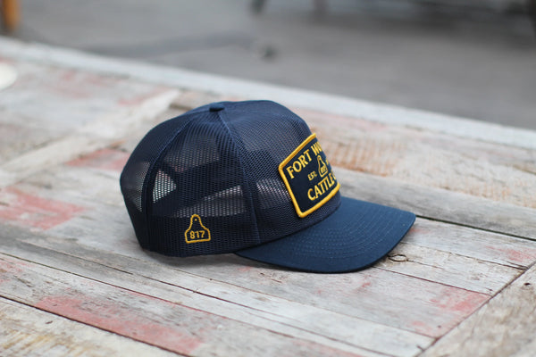 Blue cap with yellow branding on a wooden surface