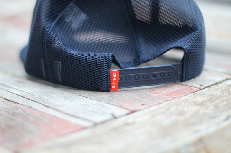 Blue mesh cap with a red tag on a wooden surface