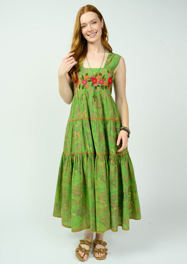 Woman wearing a green dress with floral patterns on a white background