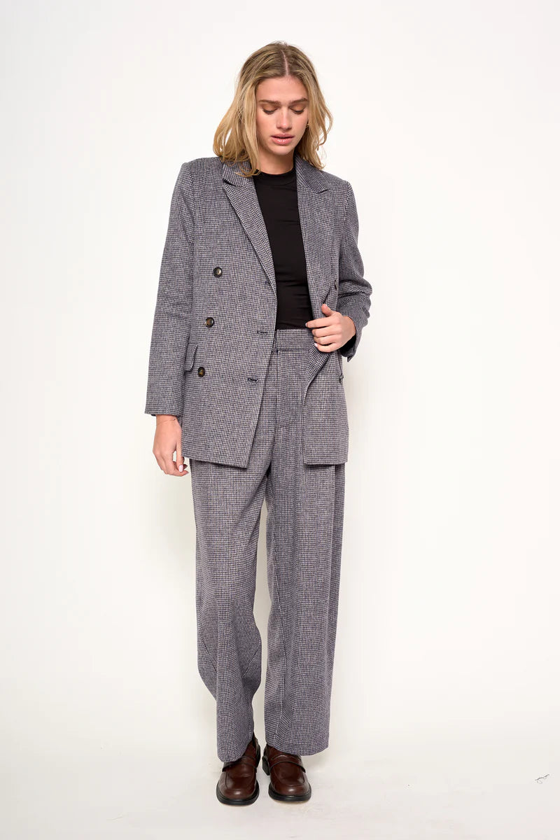 Woman wearing a gray suit with a black top on a white background
