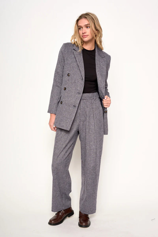 Woman wearing a gray suit with a black top on a white background