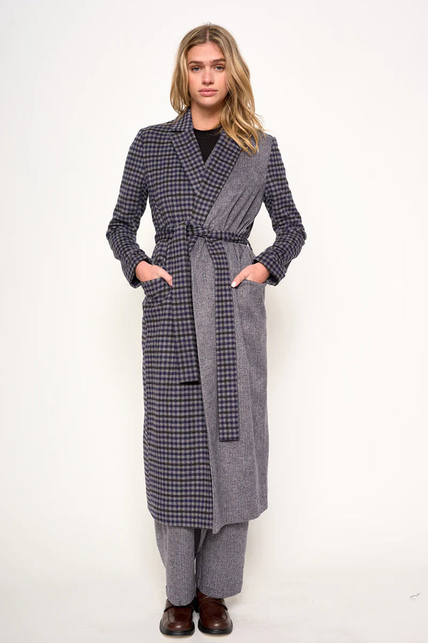 Woman wearing a long plaid coat on a white background
