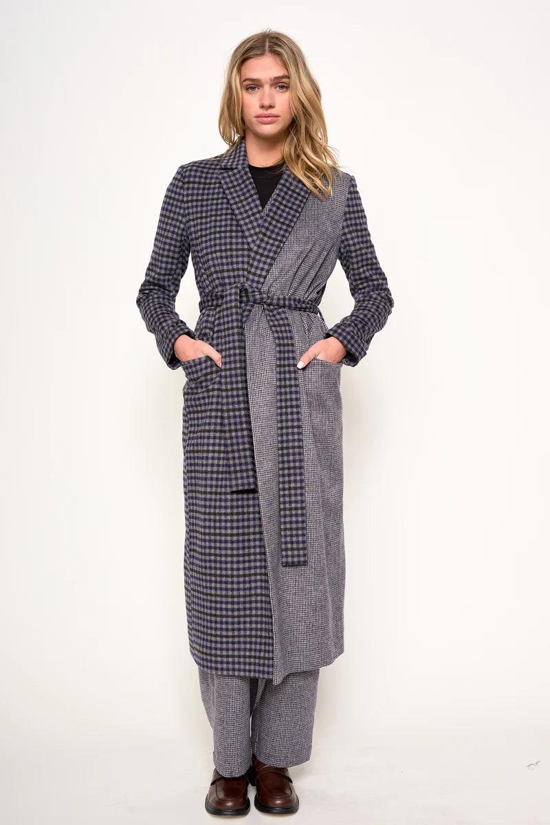 Woman wearing a long plaid coat on a white background