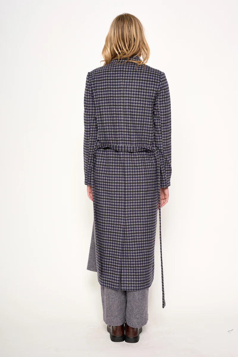 Person wearing a long checkered coat and pants on a white background