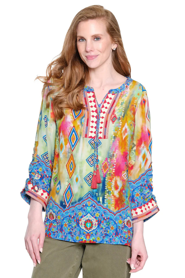 Woman wearing a colorful patterned blouse on a white background